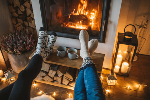 two women have their feet up in front of the fireplace