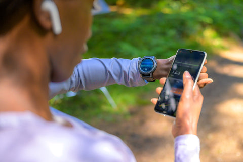 a woman prepares her watch for a run to track her progress