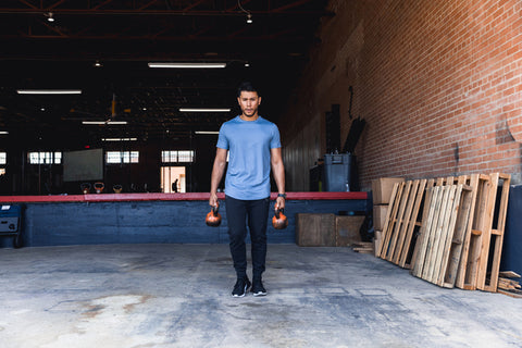 Man doing a farmer's kettlebell carry