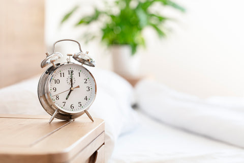 an alarm clock sitting on a bedside table