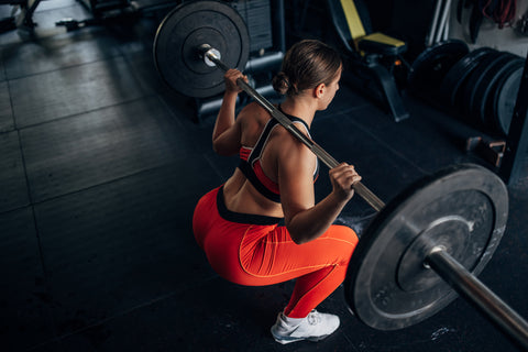 Woman squats with a barbell on her back