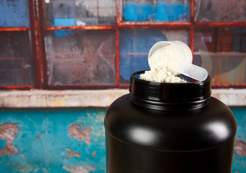 A large tub of protein powder with a scoop