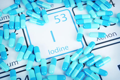 Iodine on the periodic table surrounded by iodine capsules