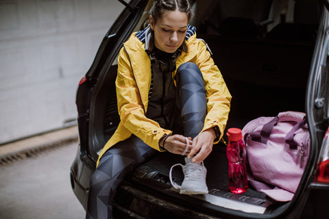 woman ties her trainers in the car