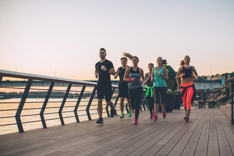 A group of runners run along a promenade