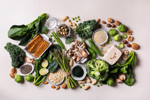 A flat lay of lots of greens and natural foods that are a good source of protein