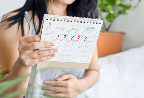 A woman planning out her menstrual phases on a calendar