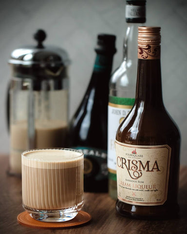 A milky brown coffee cocktail in an art nouveau glass featuring rums from Foursquare Distillery and a rum cold foam made in a french press