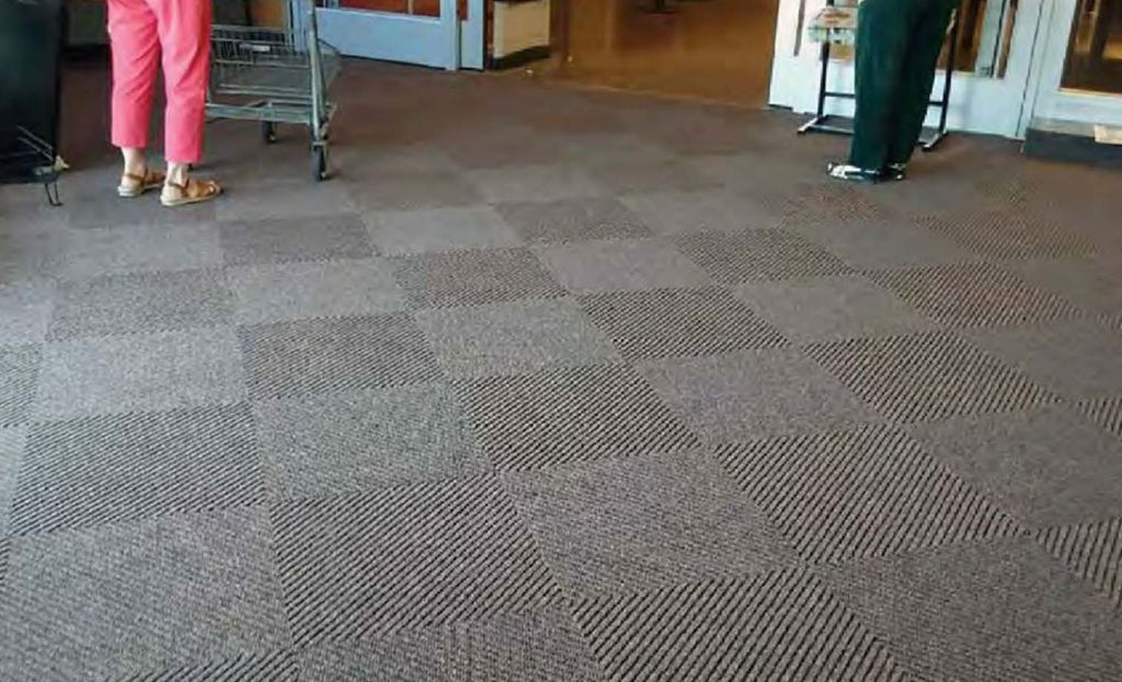 Schoonloop droogloop tapijttegels bij een ingang van een winkel