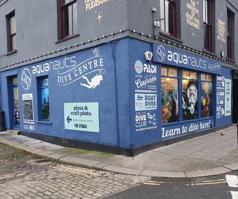 the outside of aquanauts shop - a blue exterior with scuba diving designs