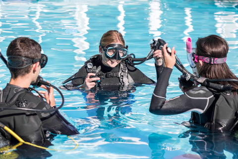 a group of people scuba diving in a pool