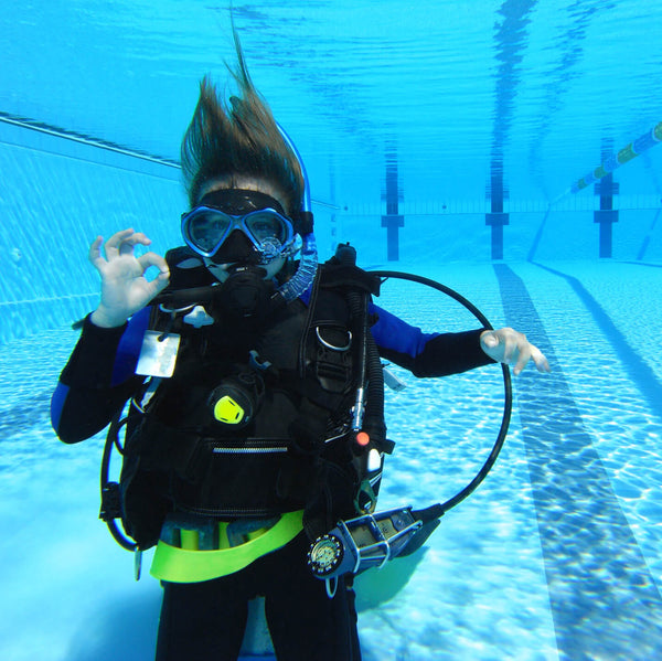 scuba diver in pool giving ok signal