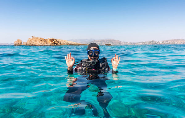 scuba diver treading water in crystal blue ocean