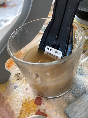 Rinsing mud spatula in a cup