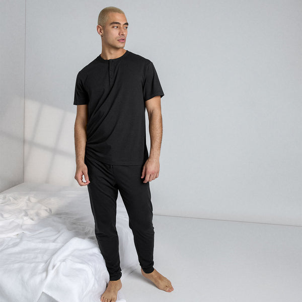 Well-rested Indian Guy in Pajamas Stretching in Bed Stock Photo