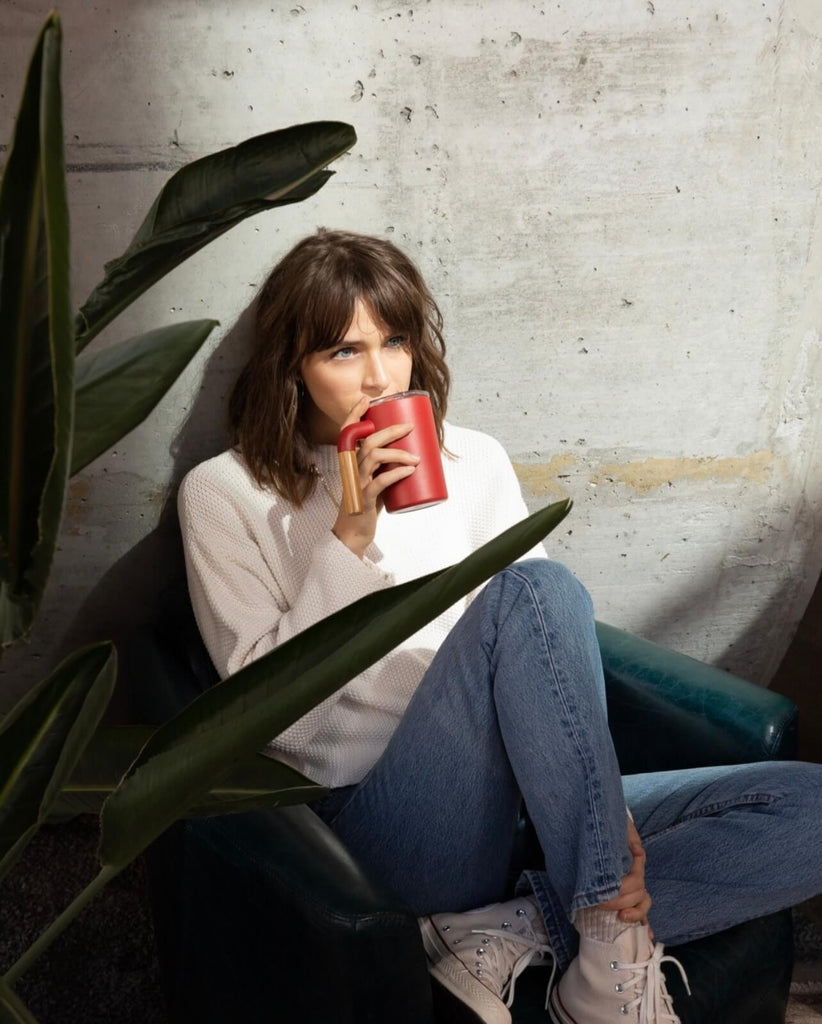 woman drinking from reusable cup