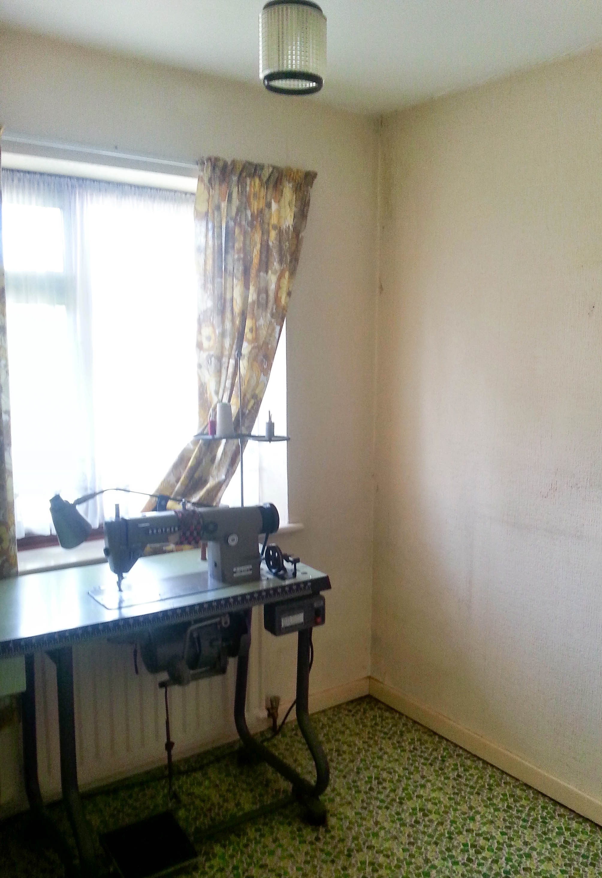 old fashioned looking bedroom with green floor and a sewing machine