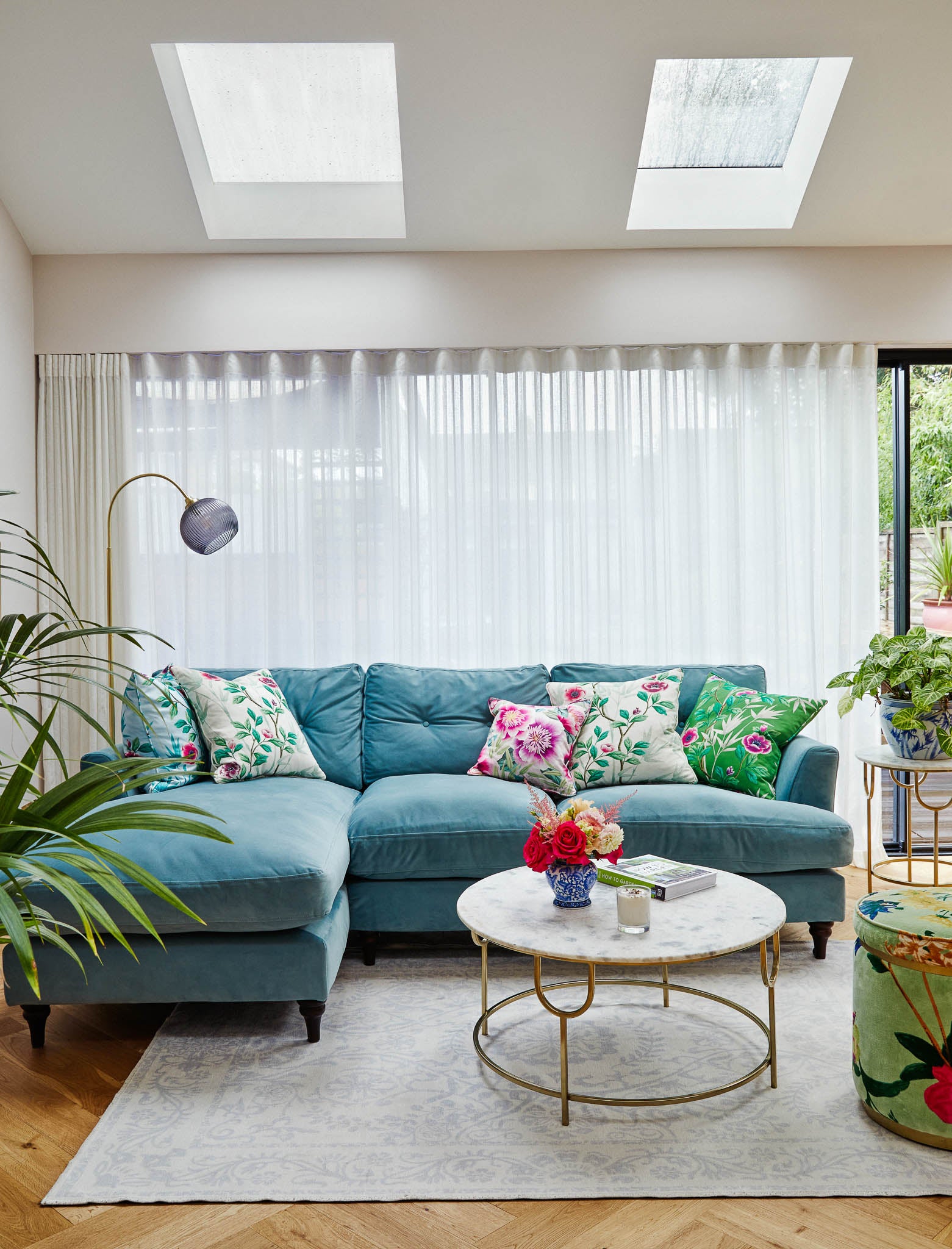 bright living room with teal velvet corner sofa, chinoiserie cushions, and modern luxury interior decor