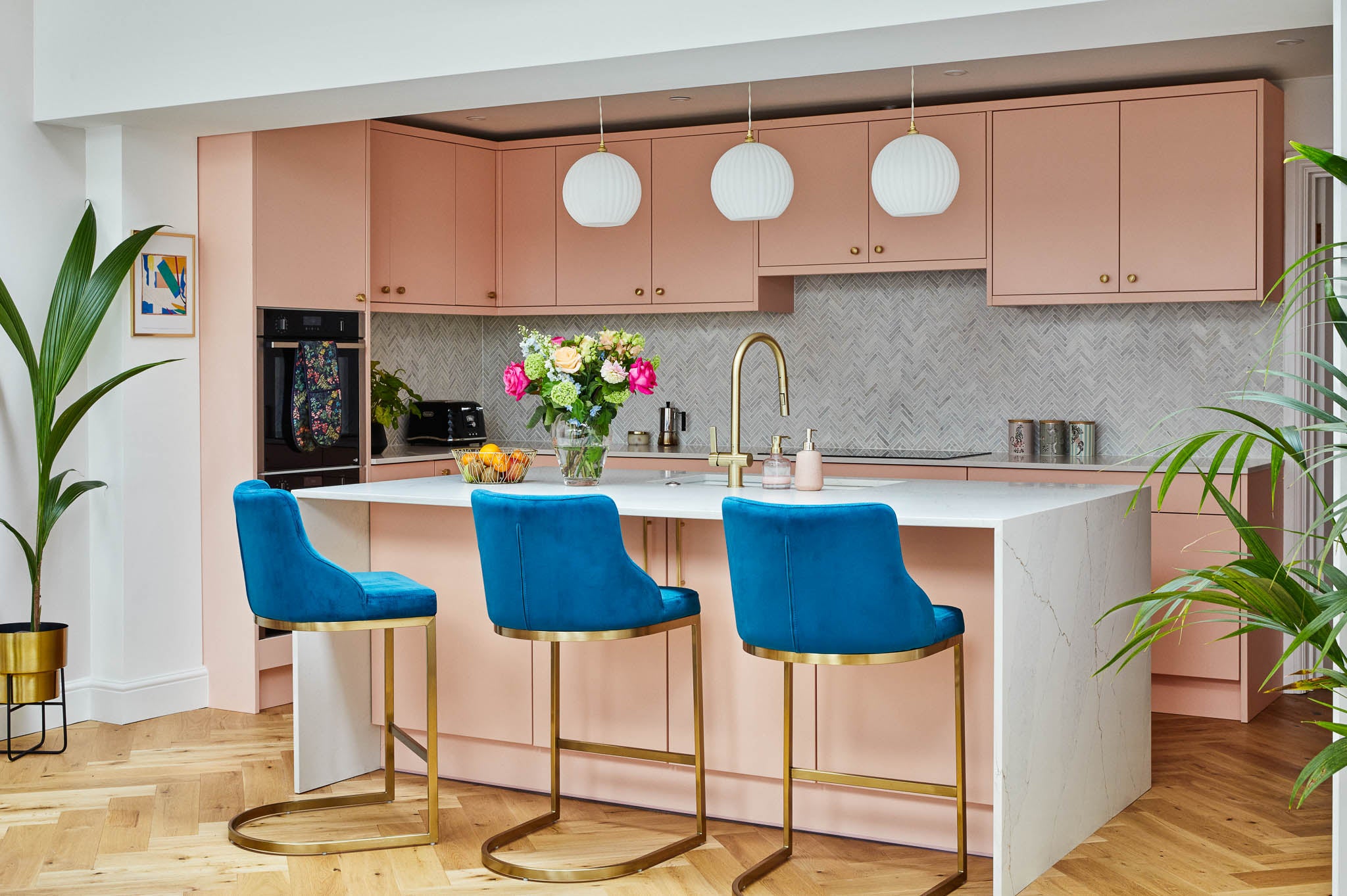 bright modern pink kitchen with blue and gold luxury bar stools