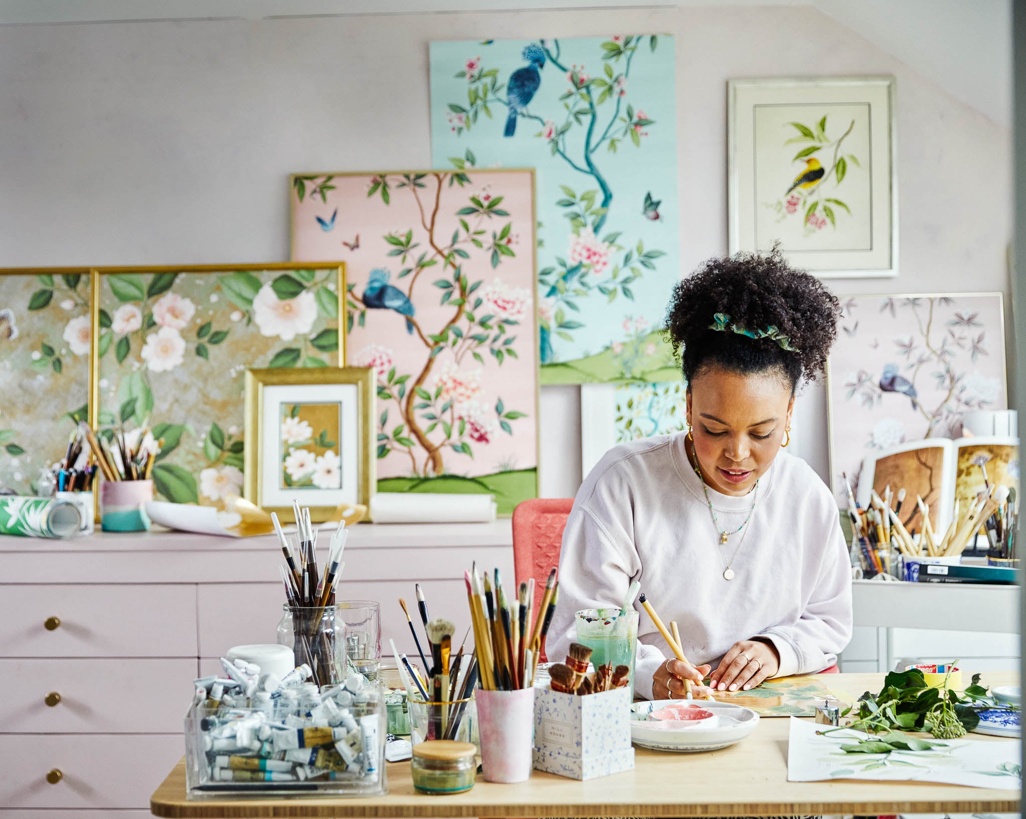 diane hill in chinoiserie art studio surrounded by original watercolor artworks and botanical and floral art prints