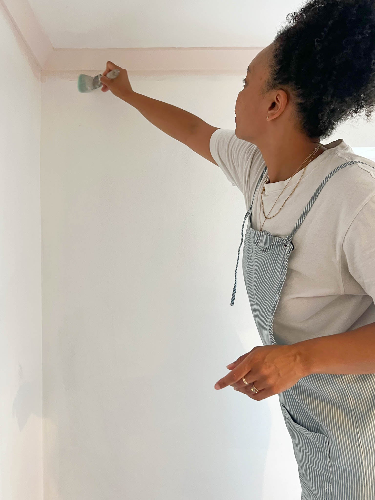 Diane Hill preparing her wall with adhesive and a brush