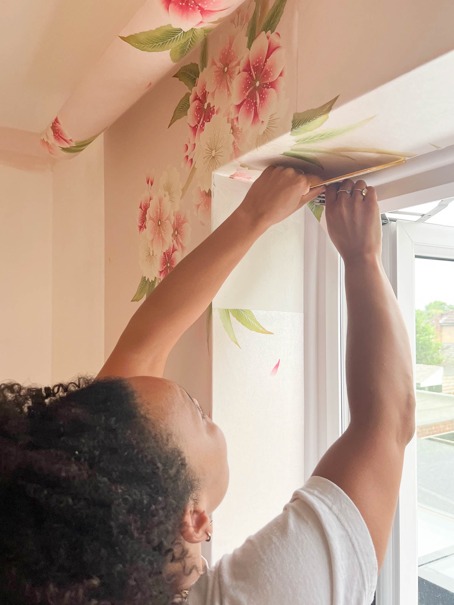 Diane Hill cutting her 'Rosa' wallpaper around the windows