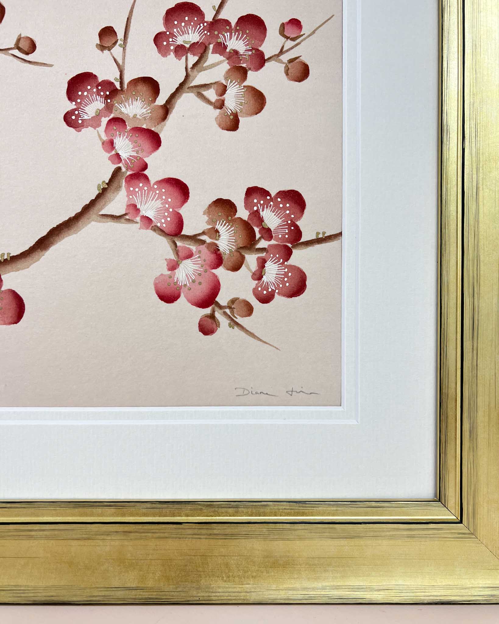Up close photograph of the detailed pink blossom flowers painted by Diane Hill on a beige background with a gold frame