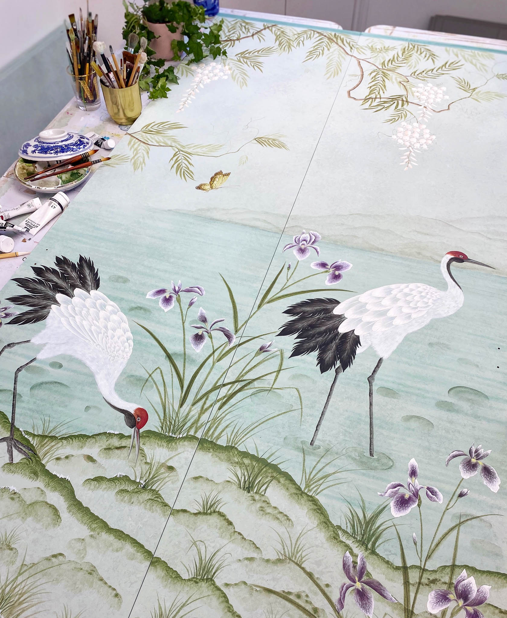 Chinoiserie scene featuring cranes and flowers hand-painted by Diane Hill onto wardrobe doors
