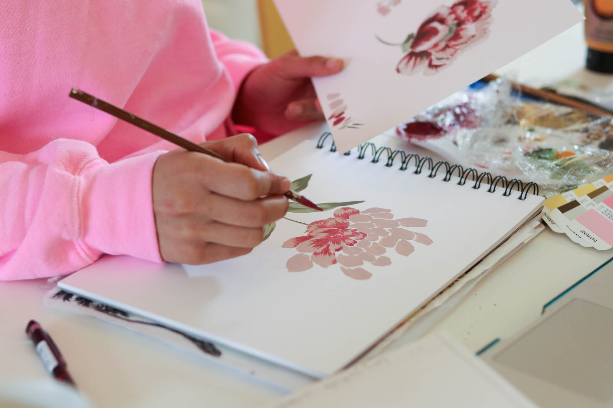 Diane Hill painting a flower in a sketch pad