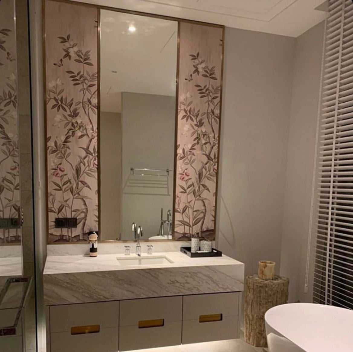 Bathroom featuring Diane Hill's 'Chinoiserie Chic' wallpaper for Rebel Walls as two wall art panels, one on each side of mirror above sink