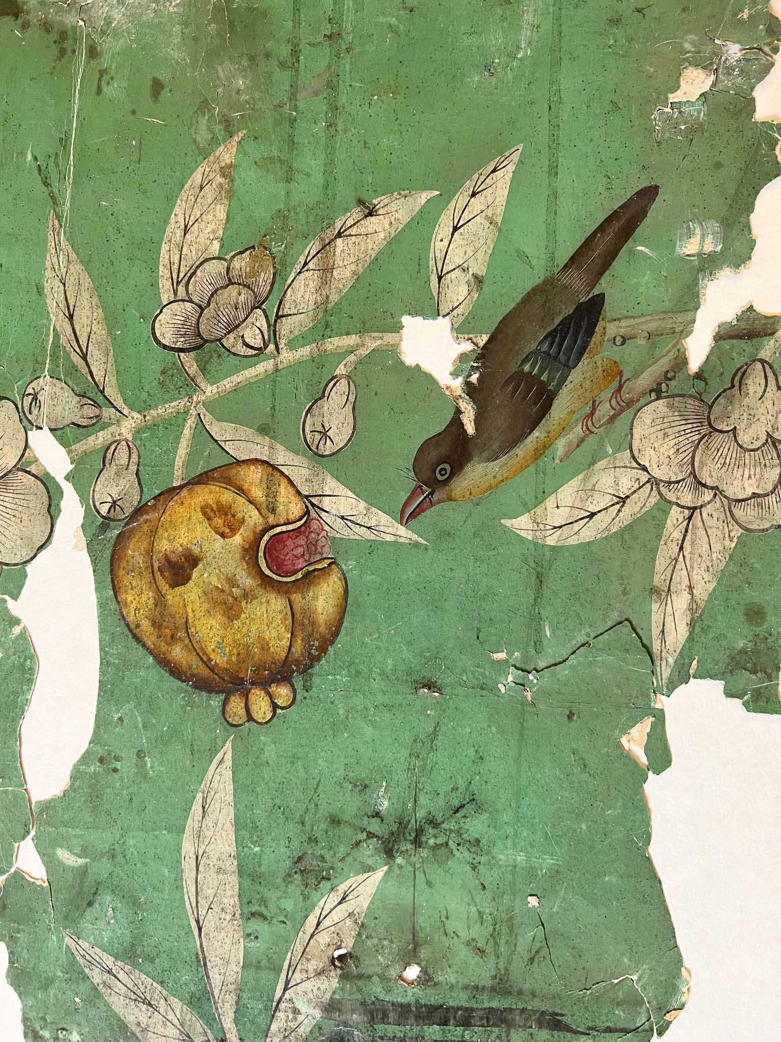 green chinoiserie wallpaper featuring a styalised pomegranate and bird motifs