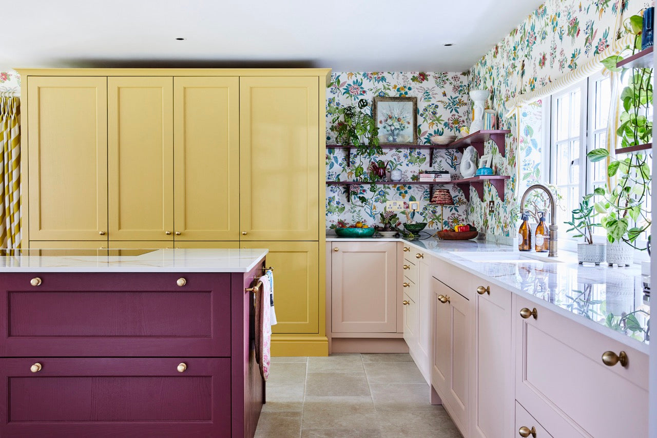 Maximalist style kitchen with colourful cupboards and sideboards paired with floral maximalist wallpaper