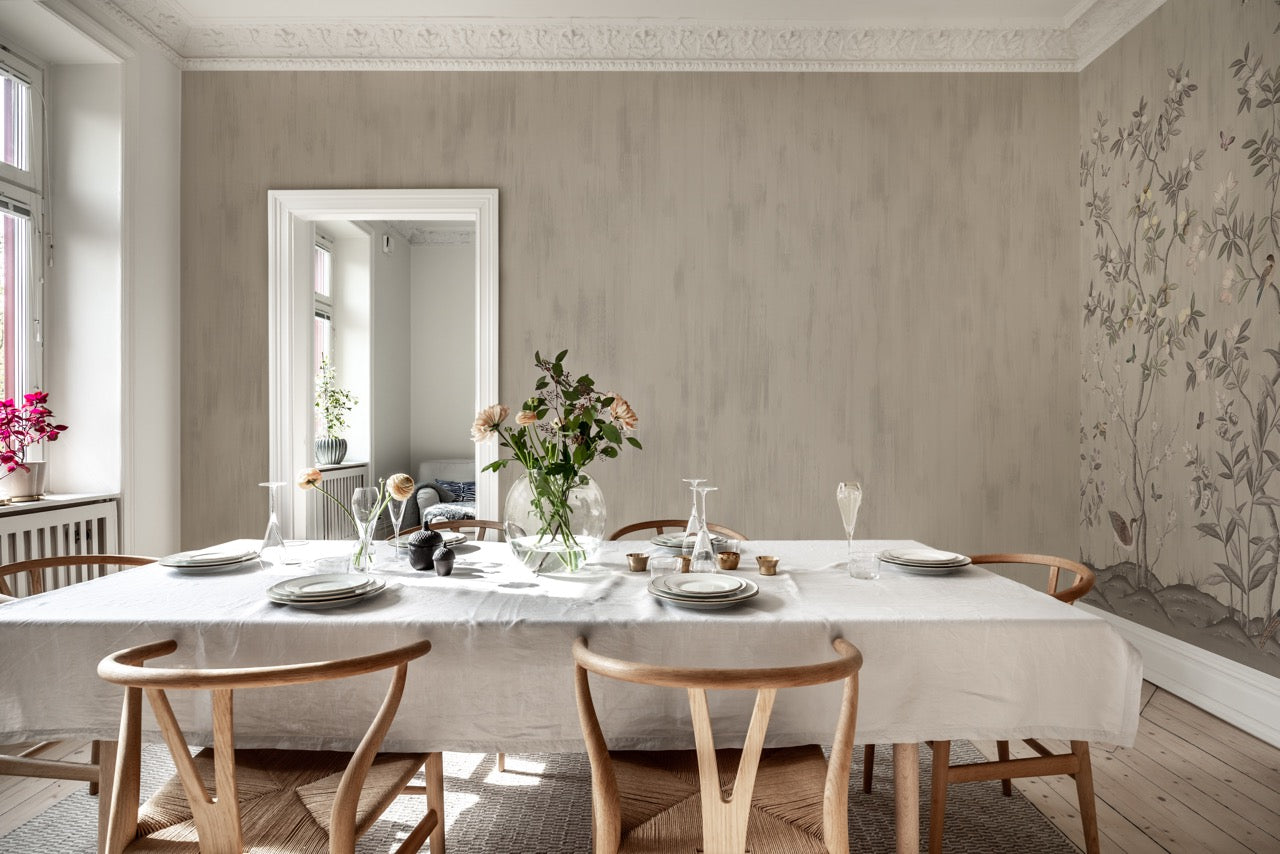 Dining room with white table cloth, flowers, and tableware featuring Diane Hill's 'Brushtrokes' and 'Chinoiserie Chic' wallpaper for Rebel Walls