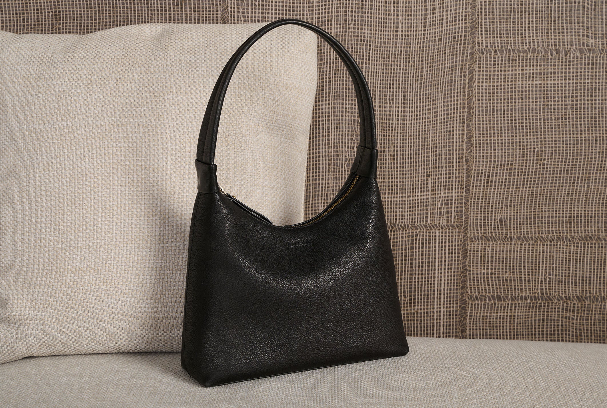 Nora slouchy shoulder bag on a sofa