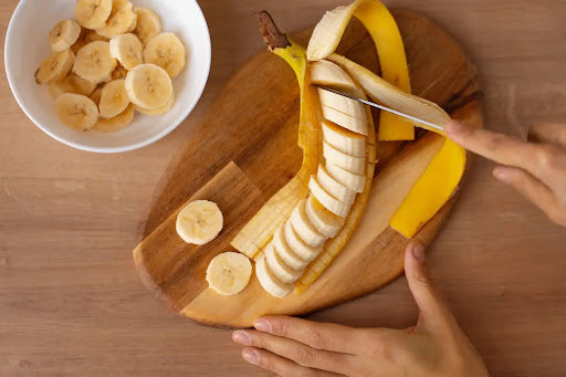 A person prepares a banana to eat and replenish their electrolytes.