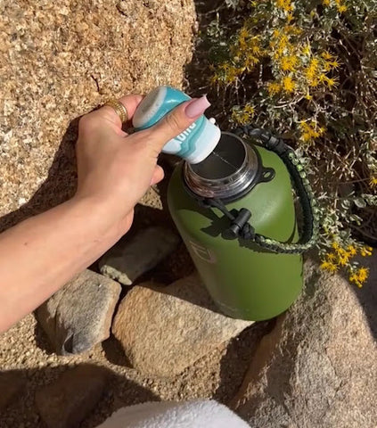 A woman adds a squeeze of Buoy to her water