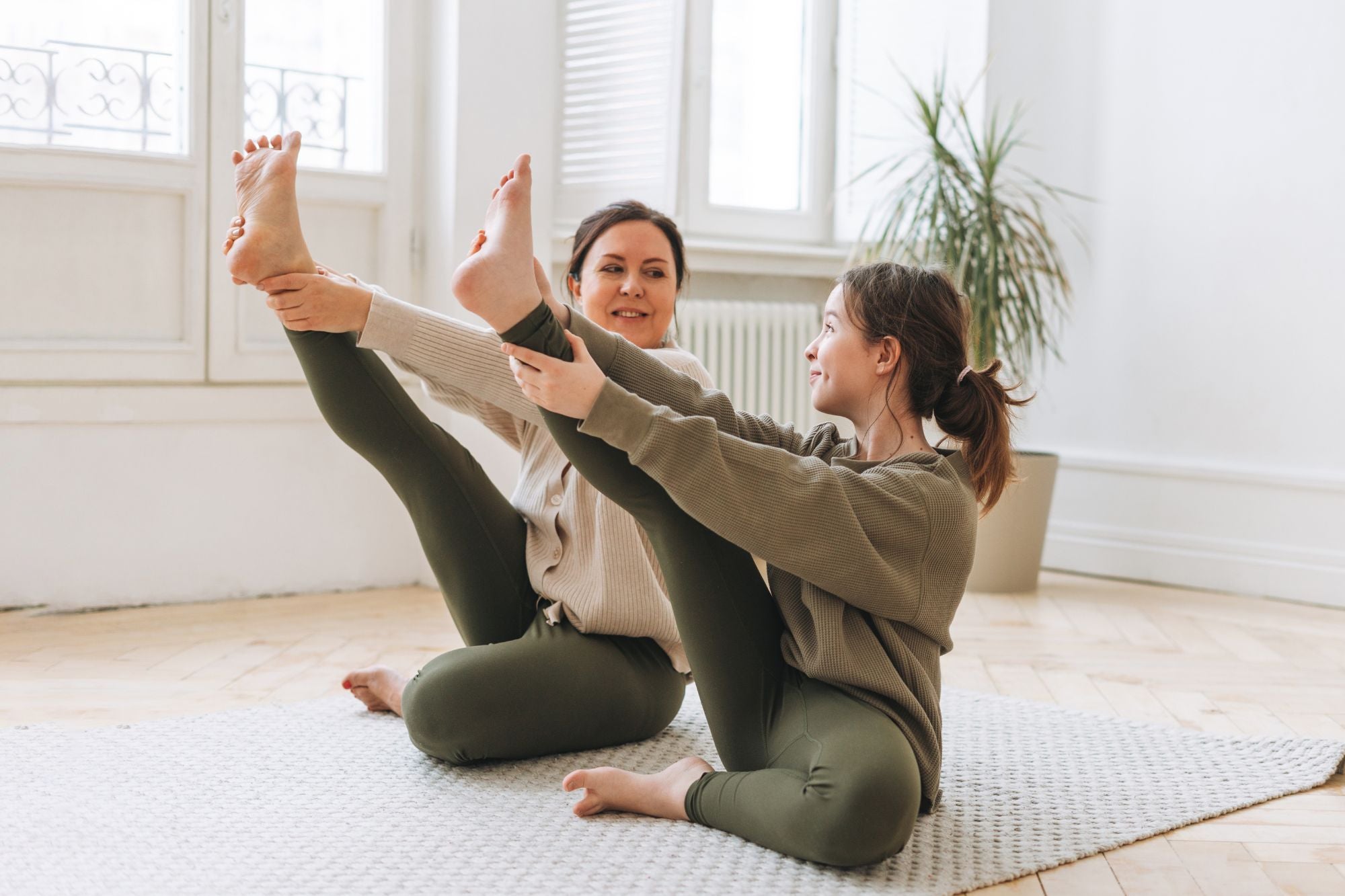 A mother and daughter practicing yoga together indoors, representing the connection between POTS and other health conditions like Ehlers-Danlos Syndrome.