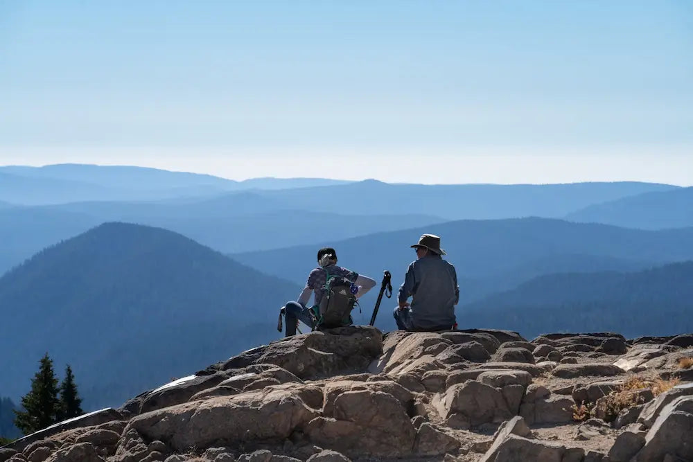Hikers sitting on top of a mountain.