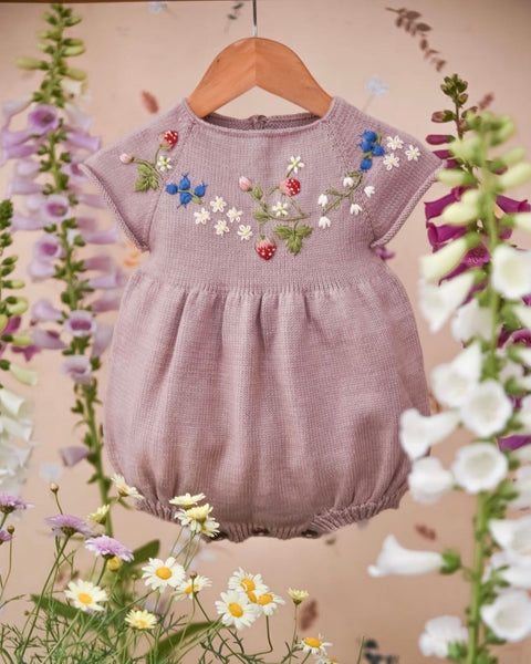 Knitted and embroidered short-sleeve romper for babies in Dahlia color with buttons between the legs.