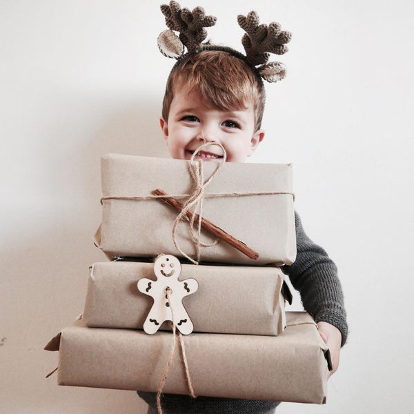 Little boy holding gifts and shirley bredal antlers on a head