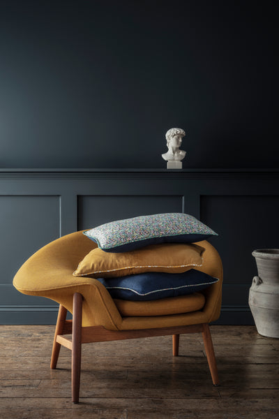 Armchair stacked with Liberty fabric cushions by Coco & Wolf.