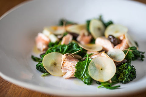Bowl of green salad with cooked salmon