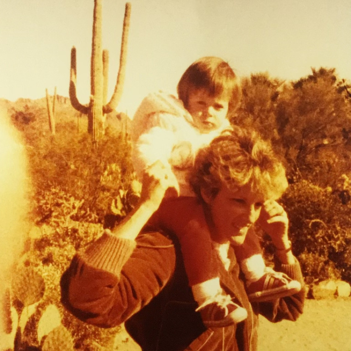 Lindsey Bull as a toddler sitting on the shoulders of her mother at a park in Arizona