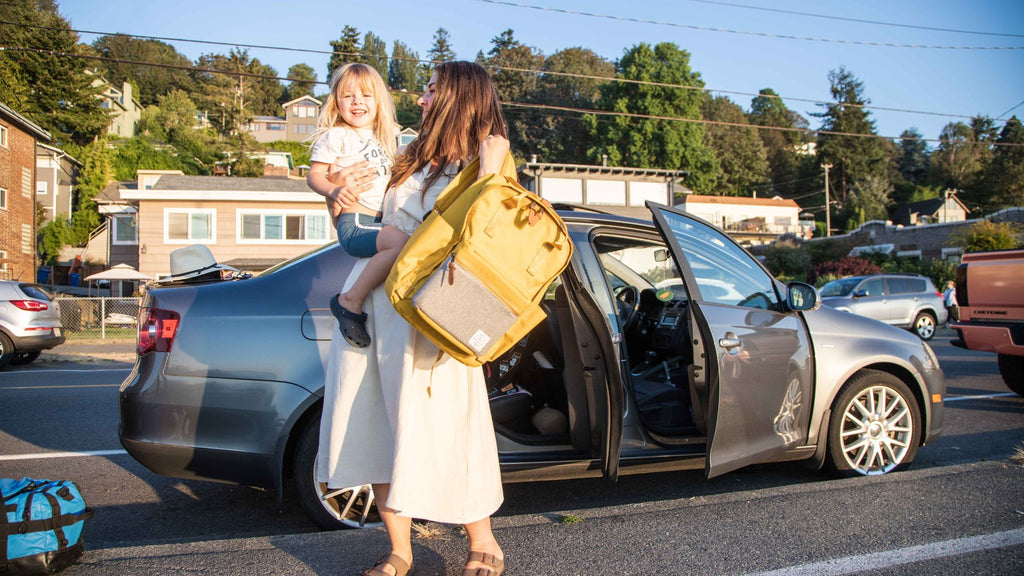 mom and daughter exit car with Elkin Diaper Bag in hand