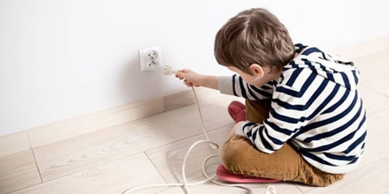 Toddler trying to plug in to an electrical outlet