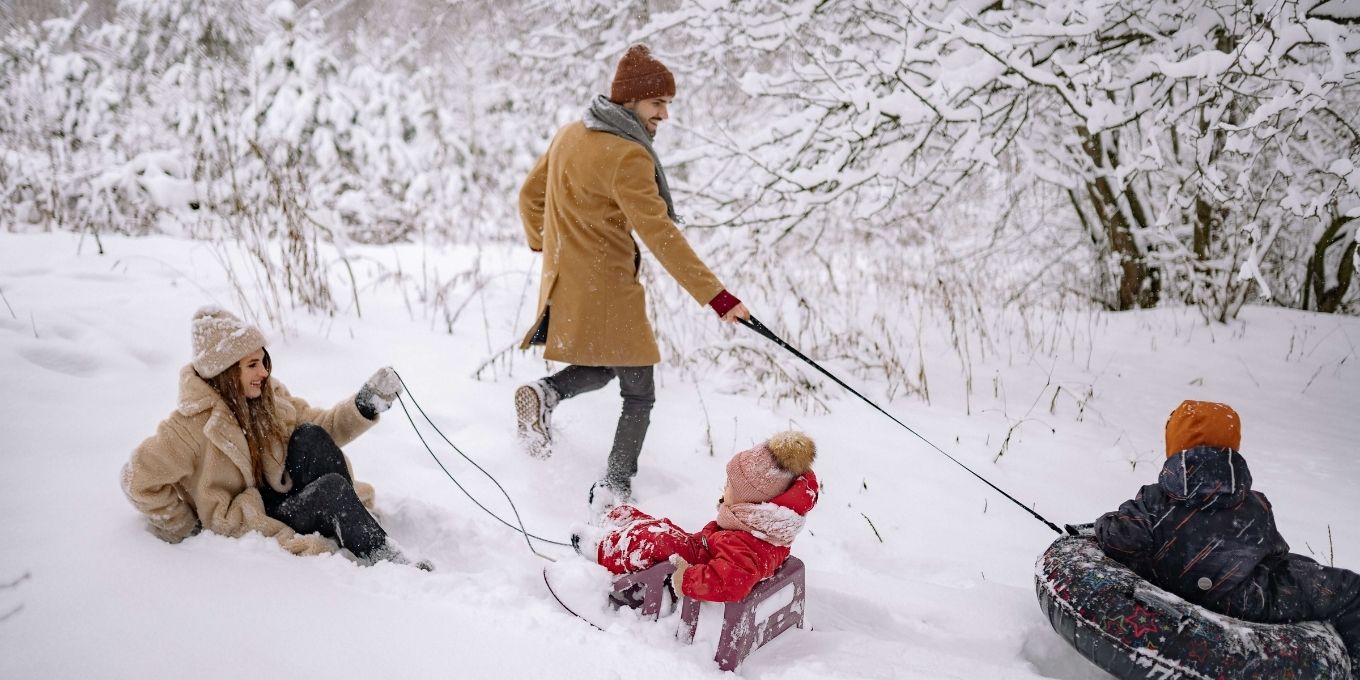 Family of four playing in the snow together