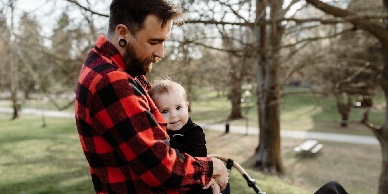 Image of father holding his son in a park