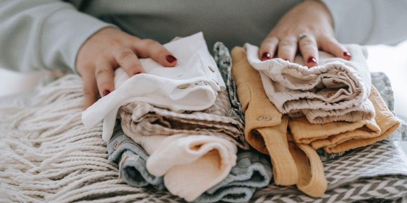 Woman folding sustainable baby clothes