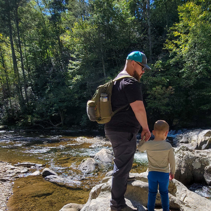 Father and son hiking near a river