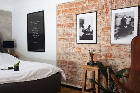 A bedroom with a large bed and an exposed brick wall.
